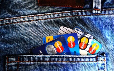 Close-up of a denim pocket with multiple credit cards, illustrating finance and fashion.